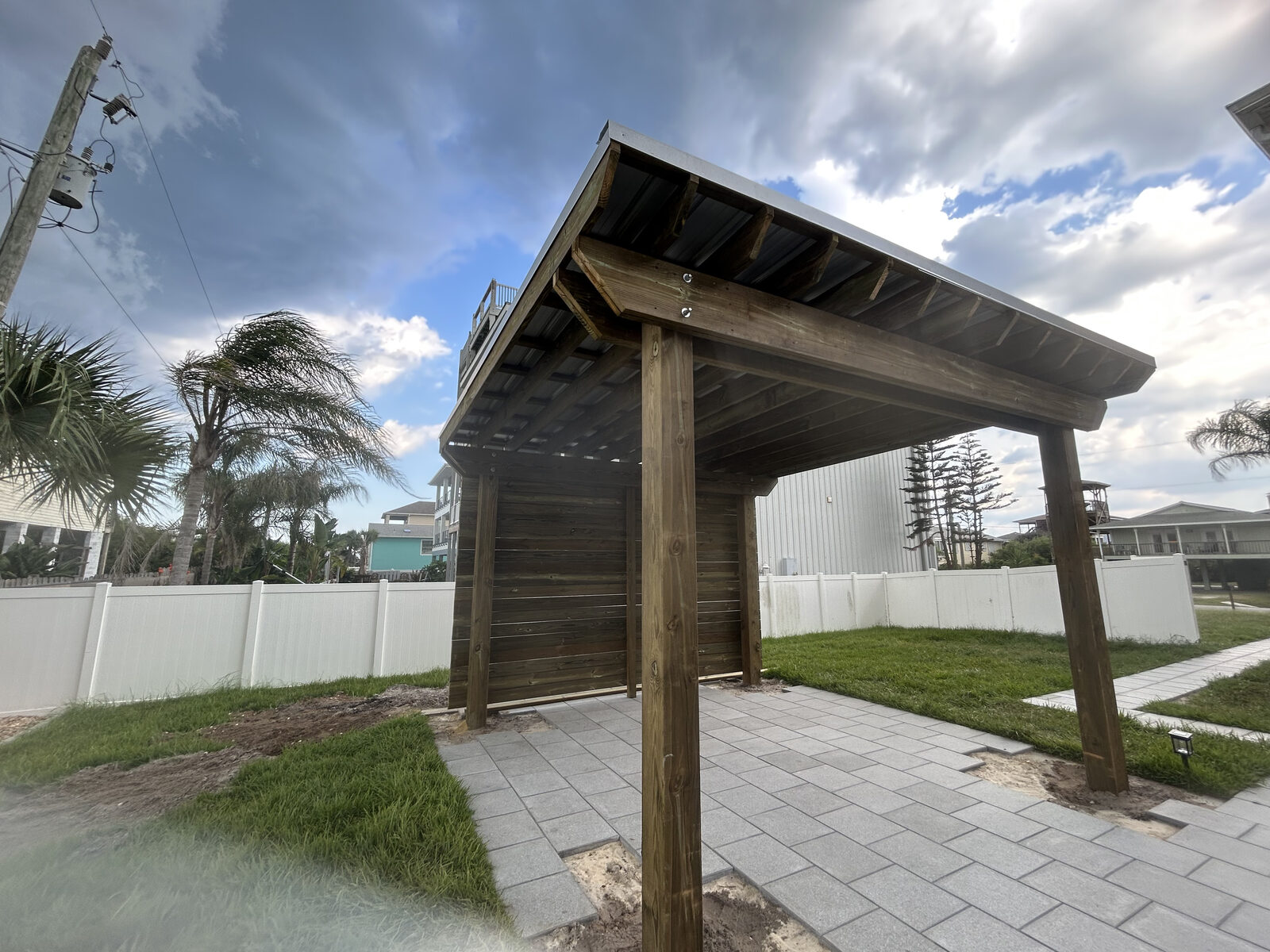 Covered wood pavilion with metal roof and privacy wall over paver patio, Neptune Beach FL