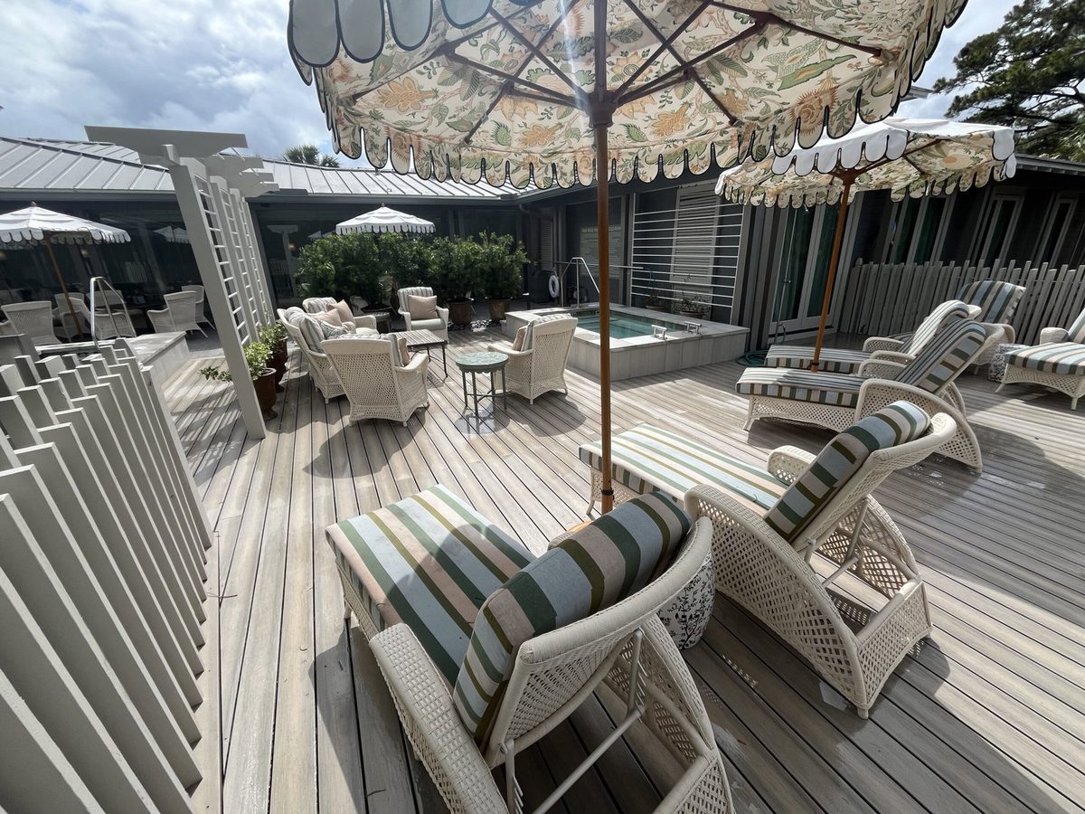 Resort-style composite spa deck with white pergola and lounge seating, built by Jacksonville Deck Builders